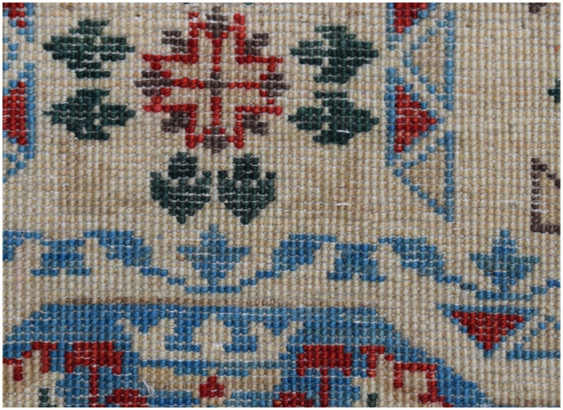 A close-up of an Afghan Chobi runner featuring intricate geometric patterns in red, blue, and green.