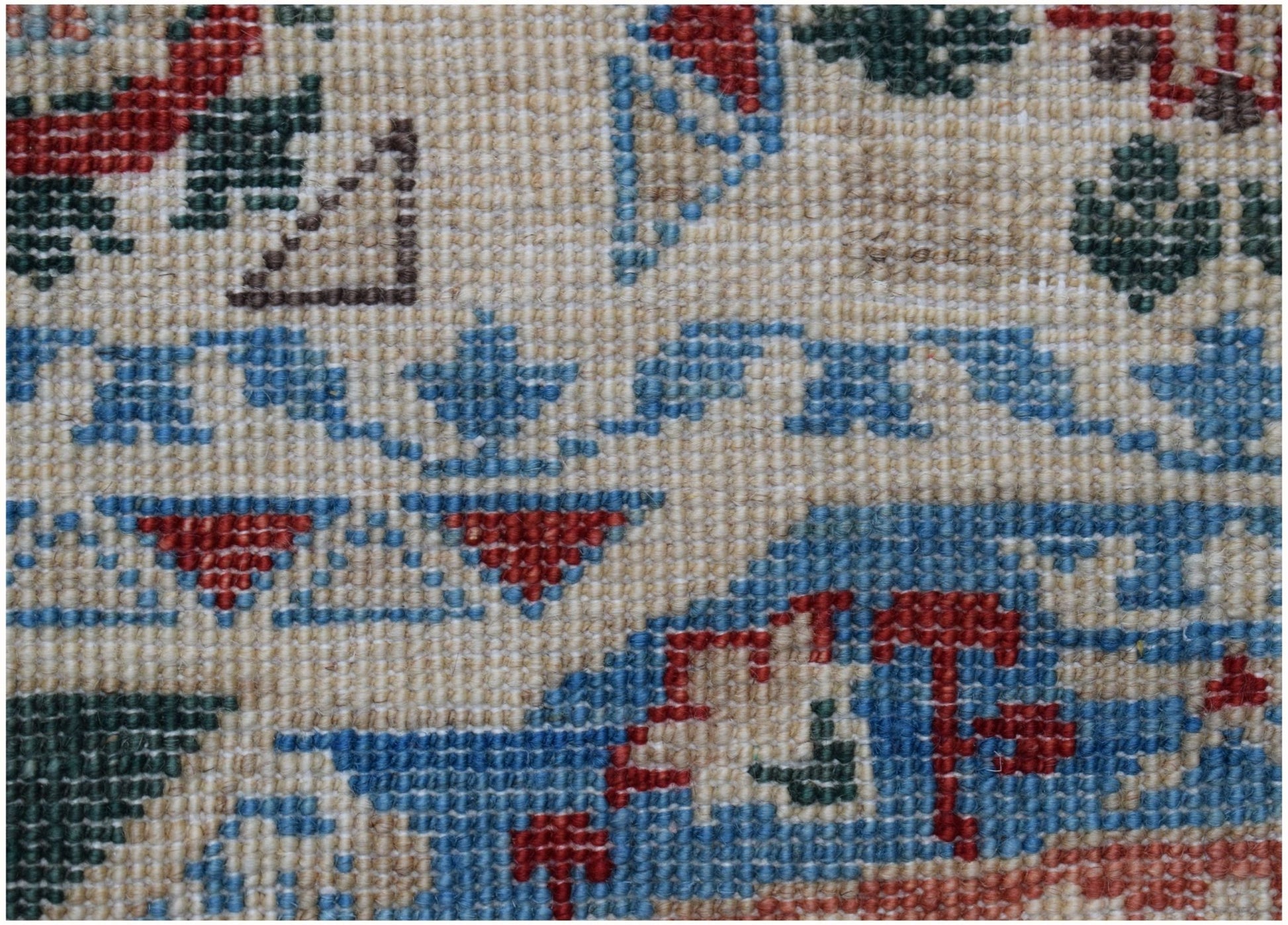A close-up of a handmade Afghan Chobi runner featuring intricate geometric patterns in wool.