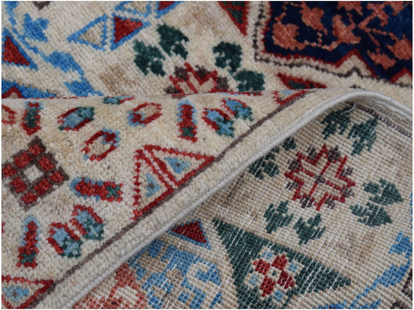 A handmade Afghan Chobi runner featuring a cream background with intricate red and blue patterns.