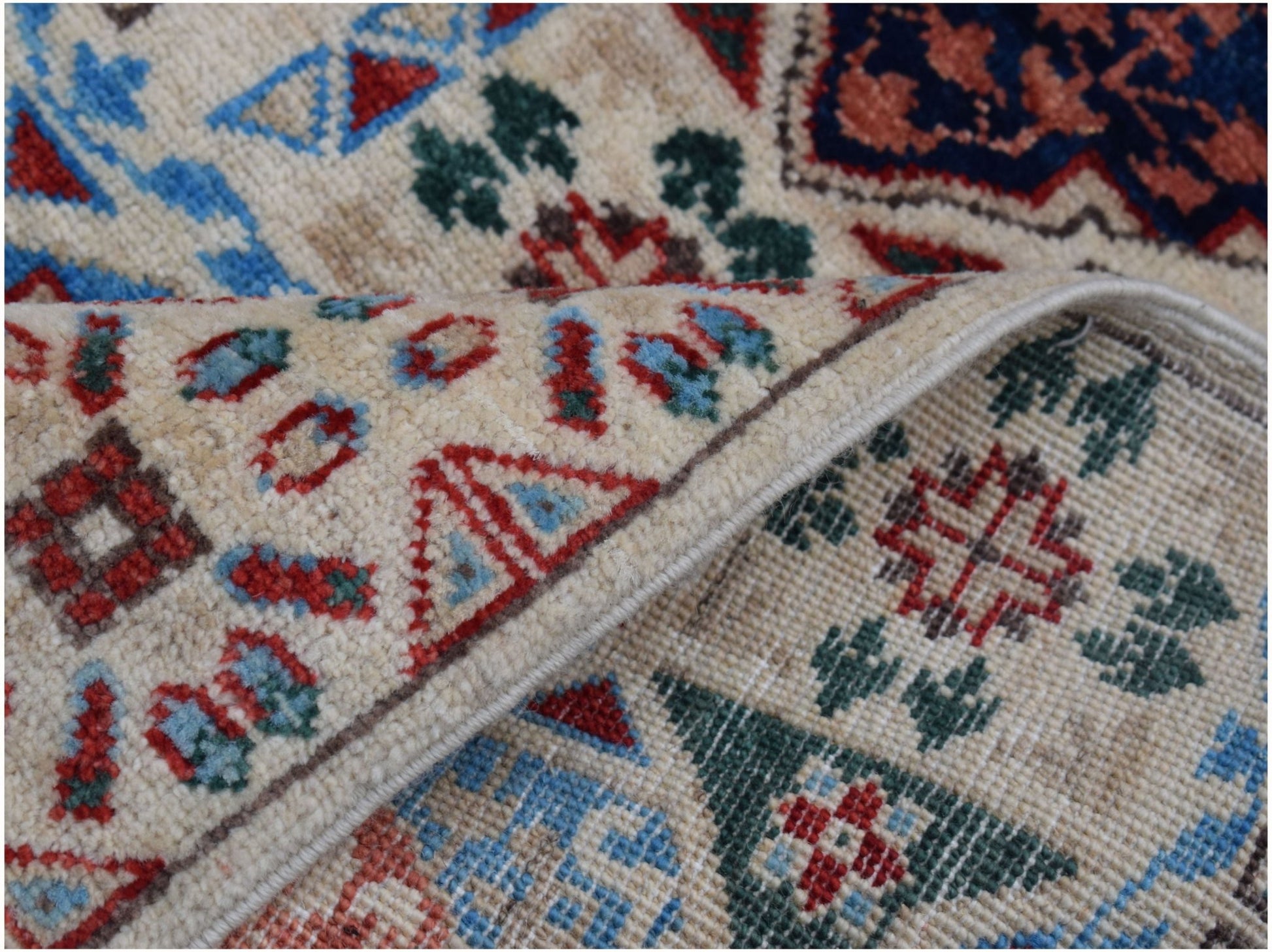 A handmade Afghan Chobi runner featuring a cream background with intricate red and blue patterns.