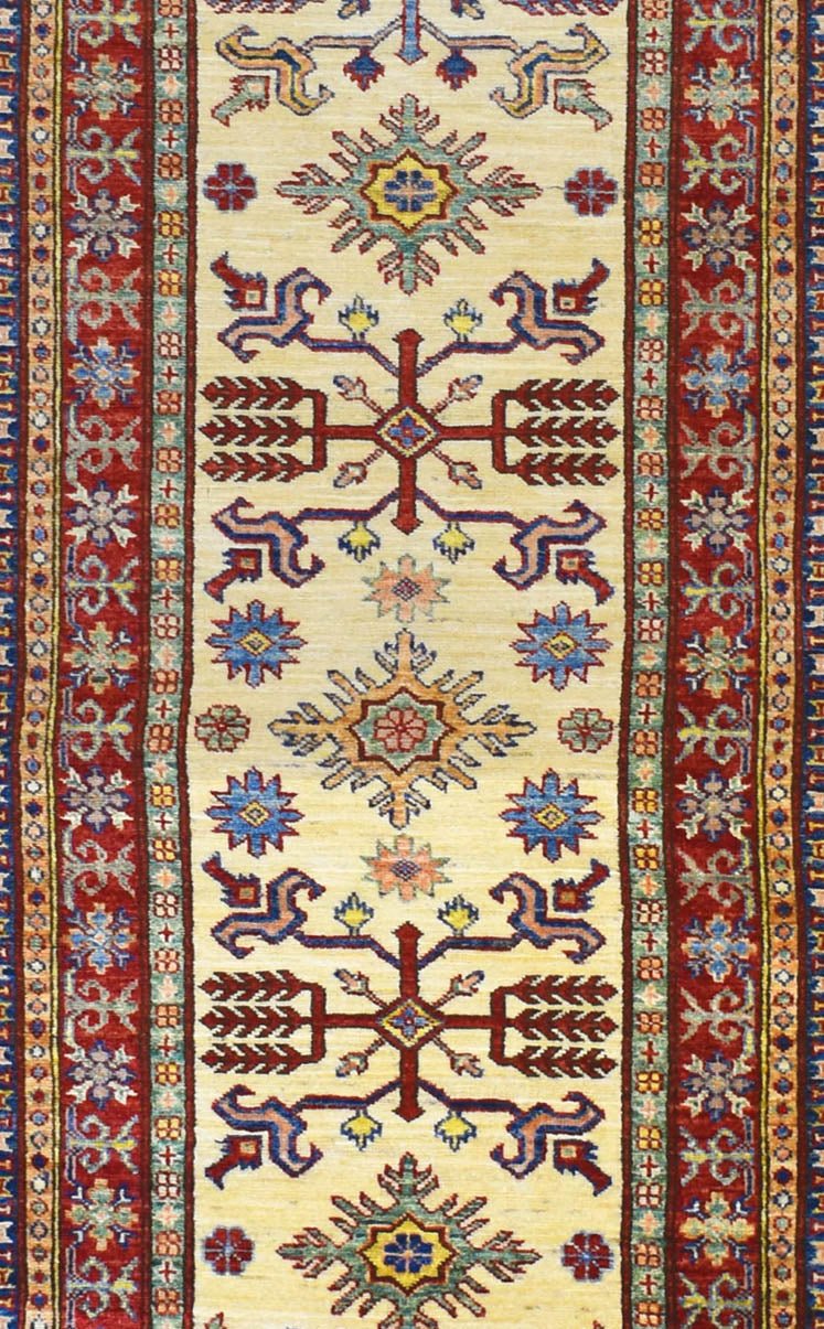 Handmade Afghan Super Kazakh runner rug featuring geometric tribal motifs in red and cream.