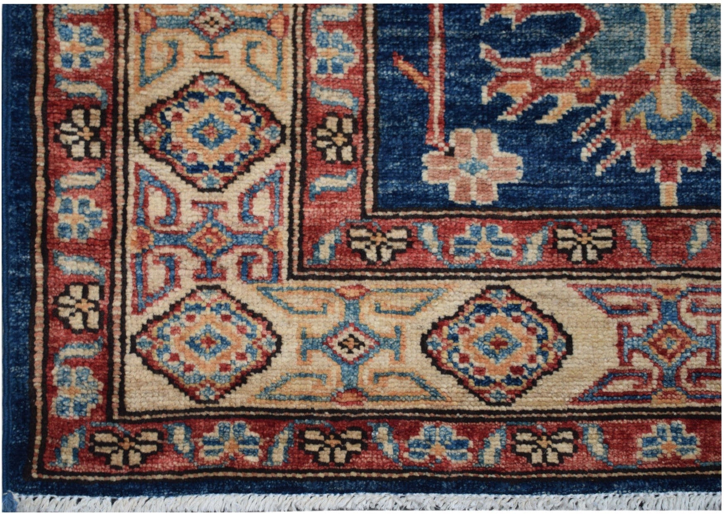 A handmade Afghan Kazakh runner rug featuring geometric patterns in blue, red, and cream.