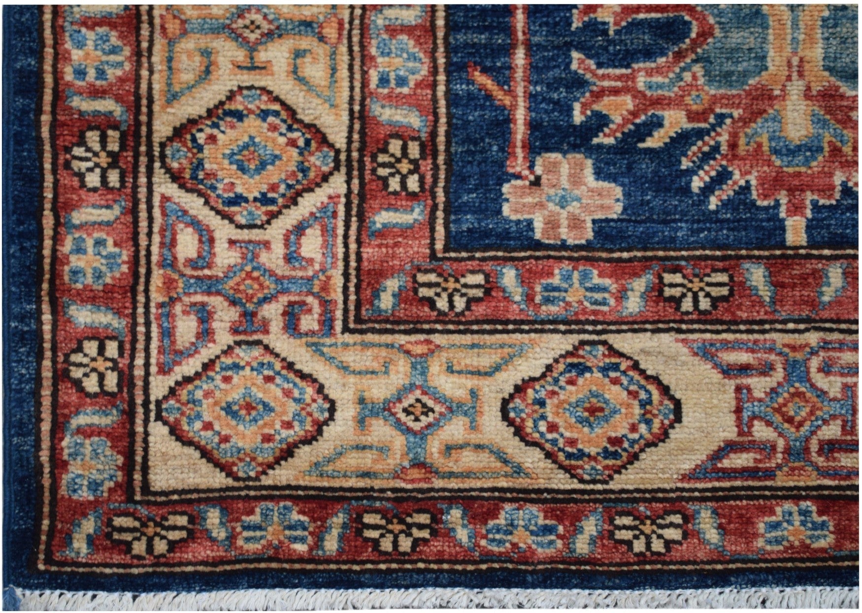 A handmade Afghan Kazakh runner rug featuring geometric patterns in blue, red, and cream.