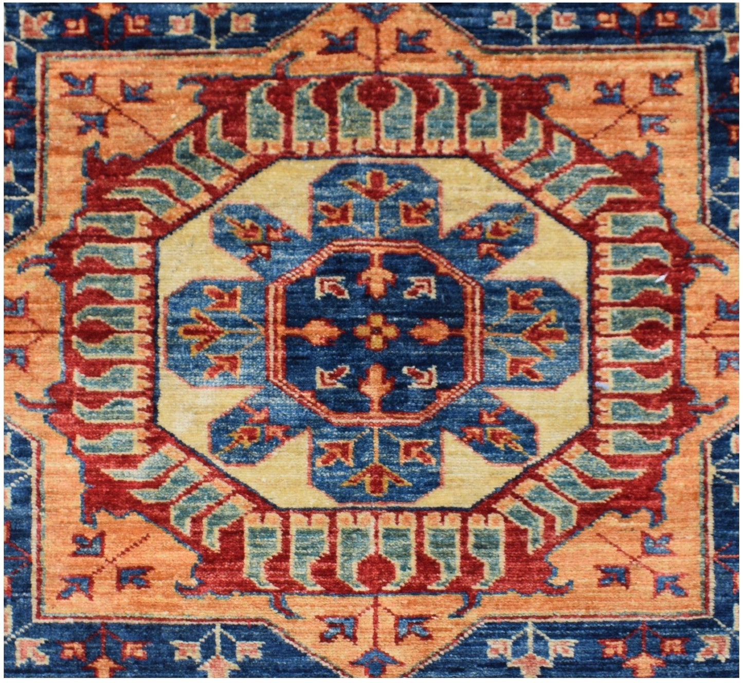 Handmade Afghan Super Kazakh rug featuring a geometric medallion in blue, red, and orange tones.