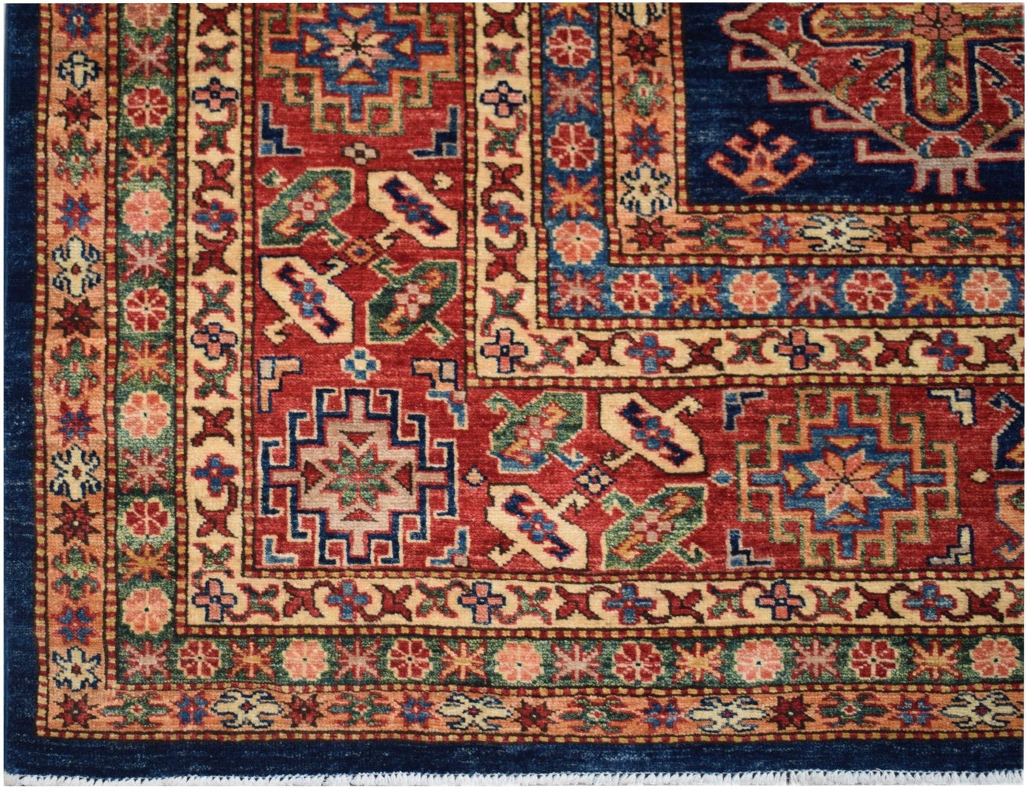 A handmade Afghan Super Kazakh rug featuring geometric patterns in red, blue, and cream tones.