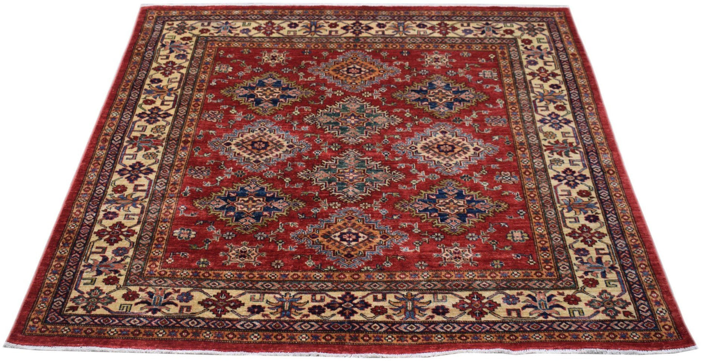 Handmade Afghan Super Kazakh rug featuring a red field with geometric medallions and floral borders.