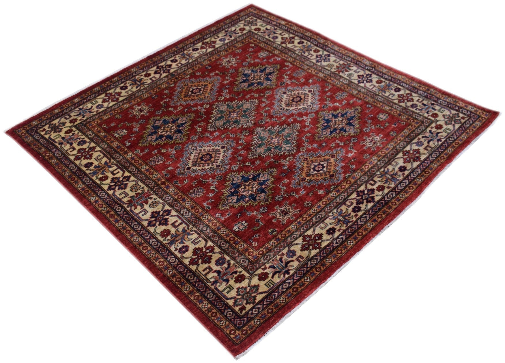 A square Afghan Super Kazakh rug featuring geometric medallions on a red field with a floral border.