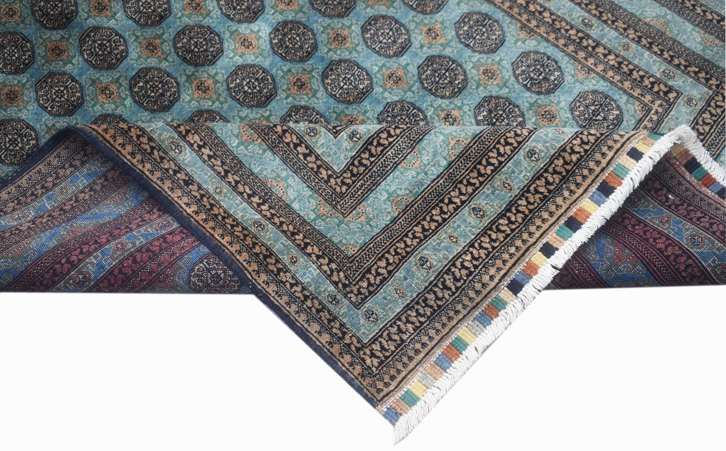 A vintage Afghan Turkmen rug with a geometric pattern in blue, brown, and cream tones.