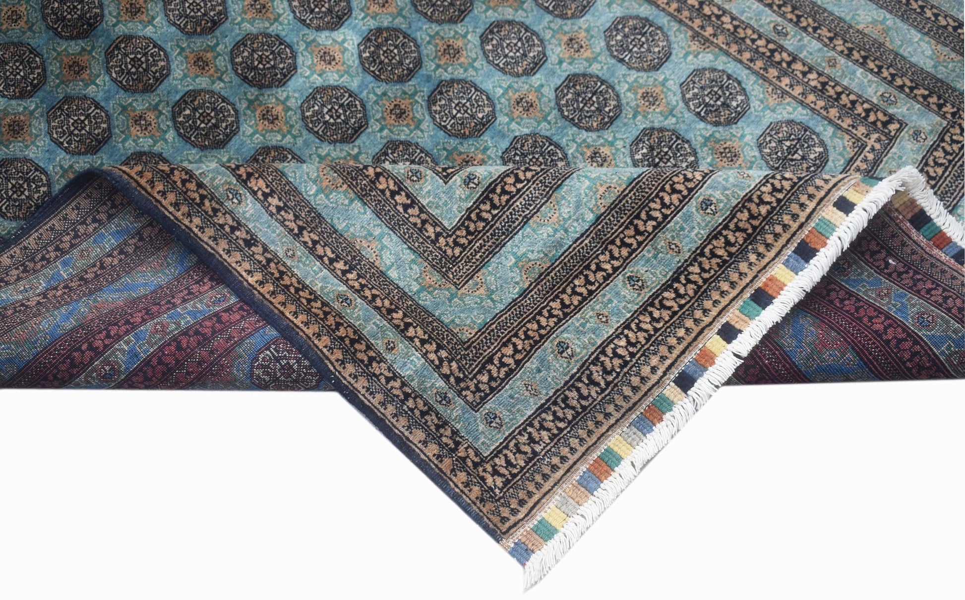 A vintage Afghan Turkmen rug with a geometric pattern in blue, brown, and cream tones.