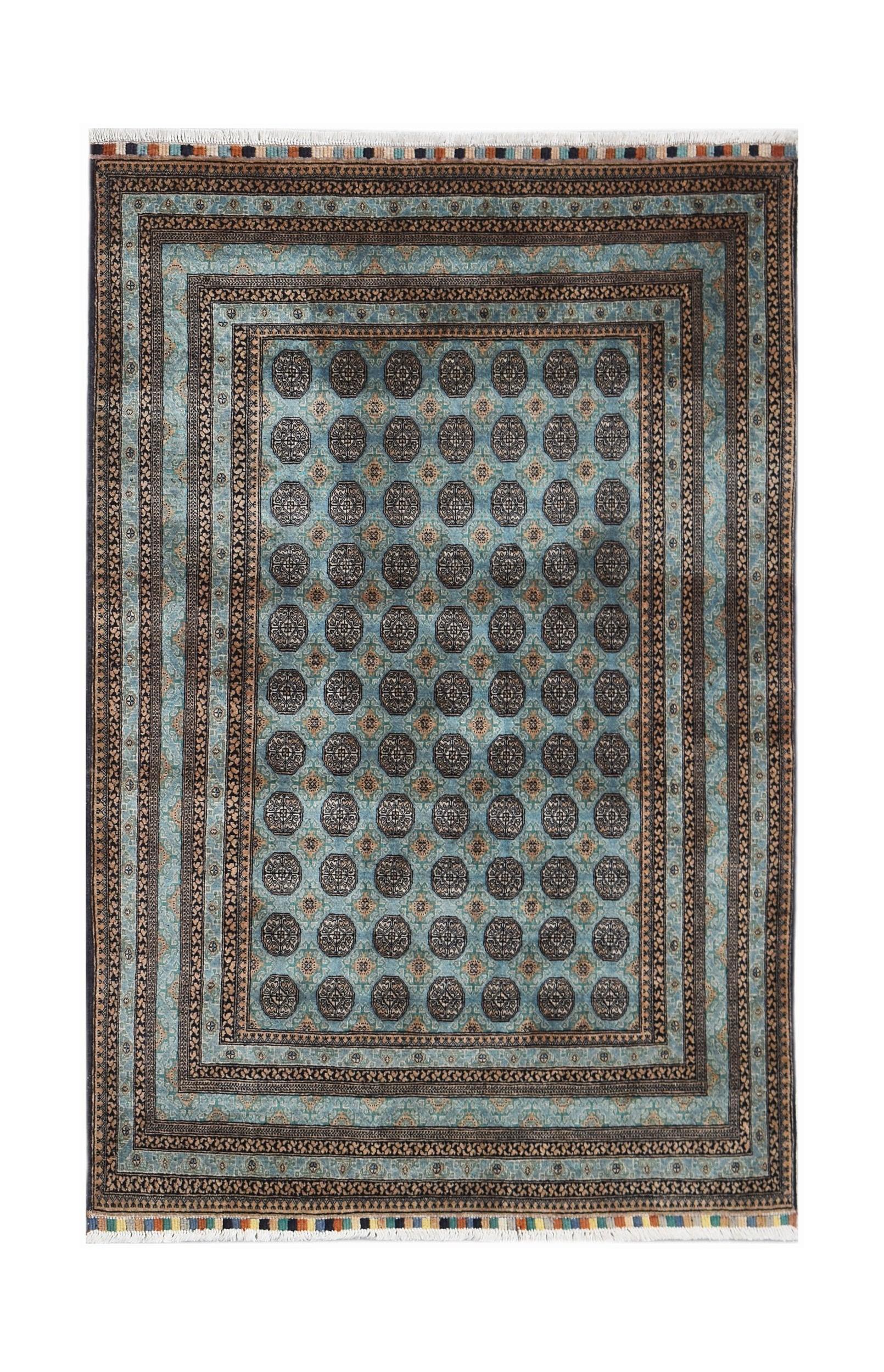 A vintage Afghan Turkmen rug featuring a repeating geometric pattern in blue and dark brown tones.