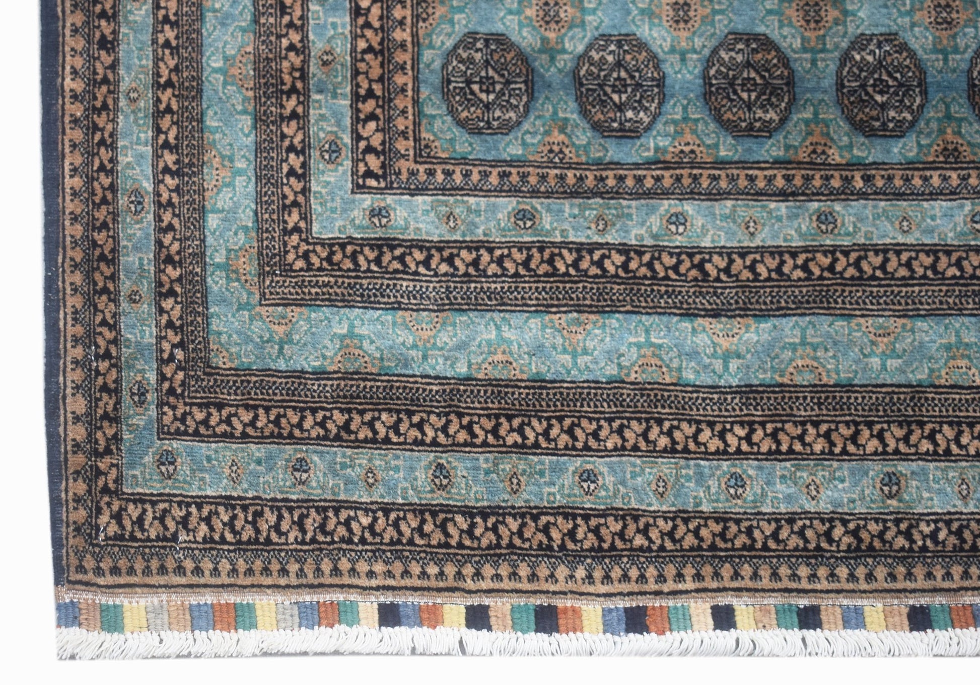 A vintage Afghan Turkmen rug featuring geometric patterns in shades of blue and brown.