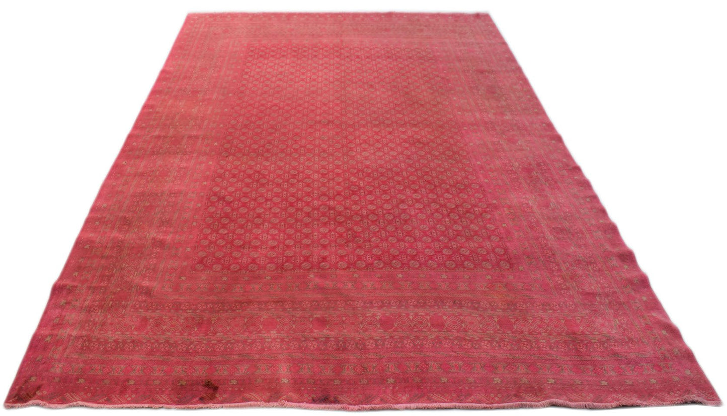 A vintage handmade Afghan Turkmen rug featuring a repeating geometric pattern in shades of red.