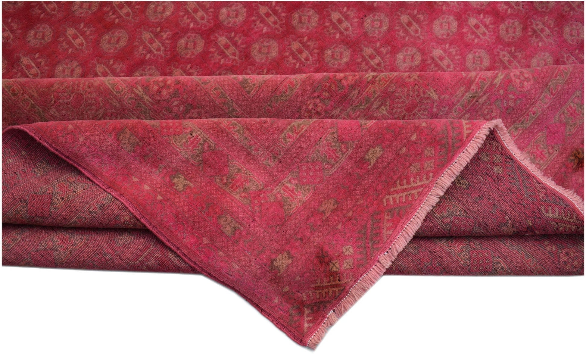 A vintage Afghan Turkmen rug in shades of red with a geometric pattern and a fringed edge.
