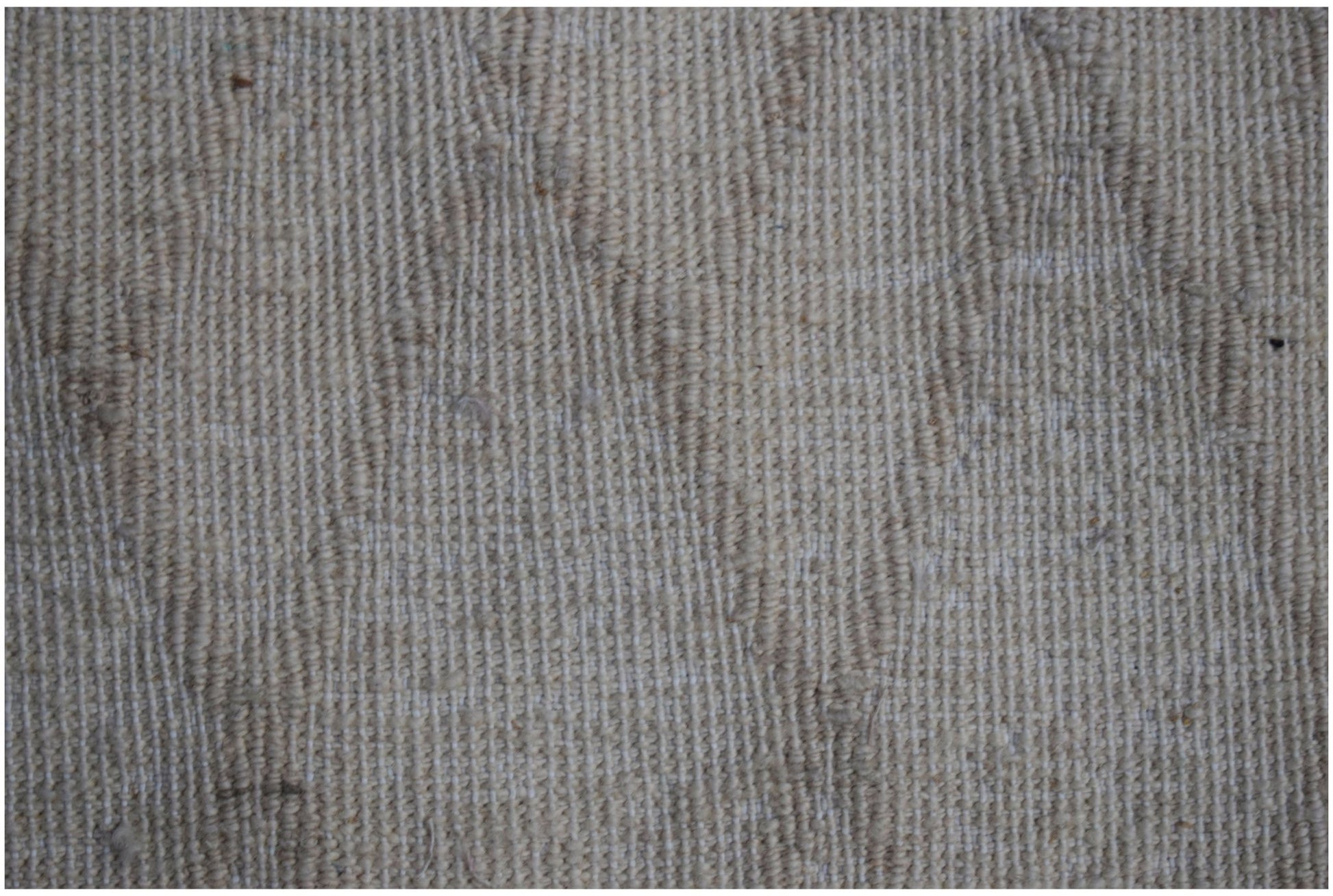 A close-up view of a handmade Afghan Yekta rug featuring a textured, neutral-toned wool weave.