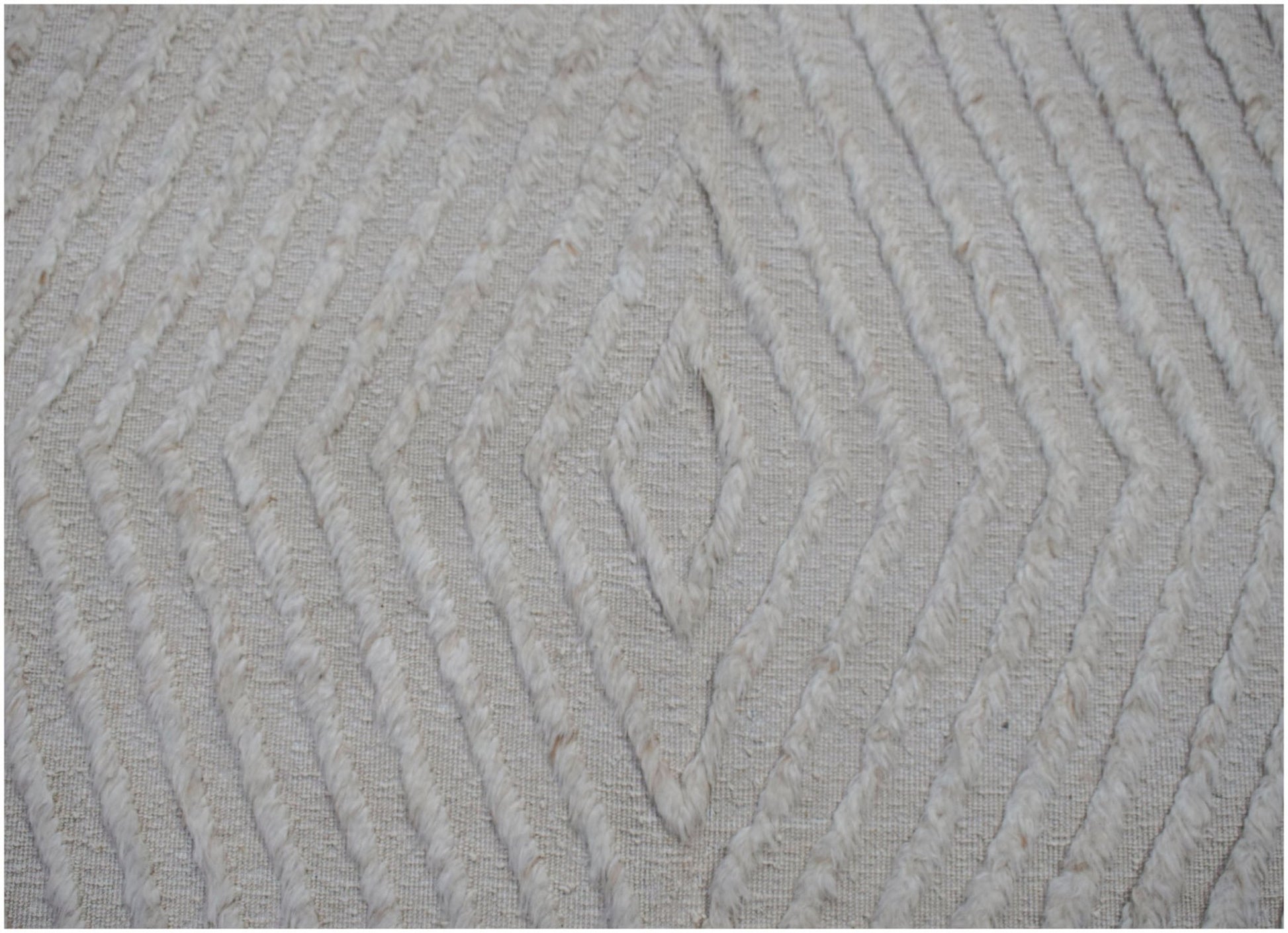 A handmade Afghan Yekta rug featuring a textured, cream-colored diamond pattern.