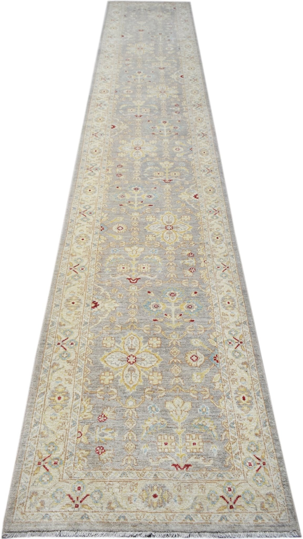 A handmade Afghan Chobi runner rug featuring traditional floral patterns in soft neutral tones.
