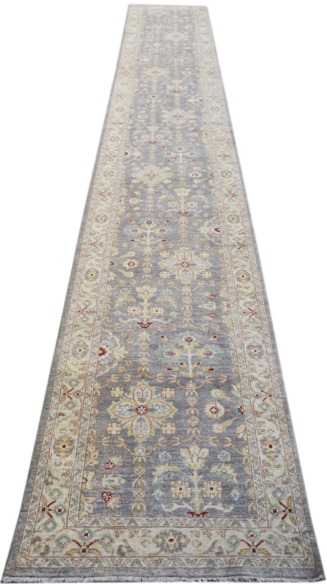 A long, handmade Afghan Chobi runner rug featuring traditional floral patterns in muted tones.