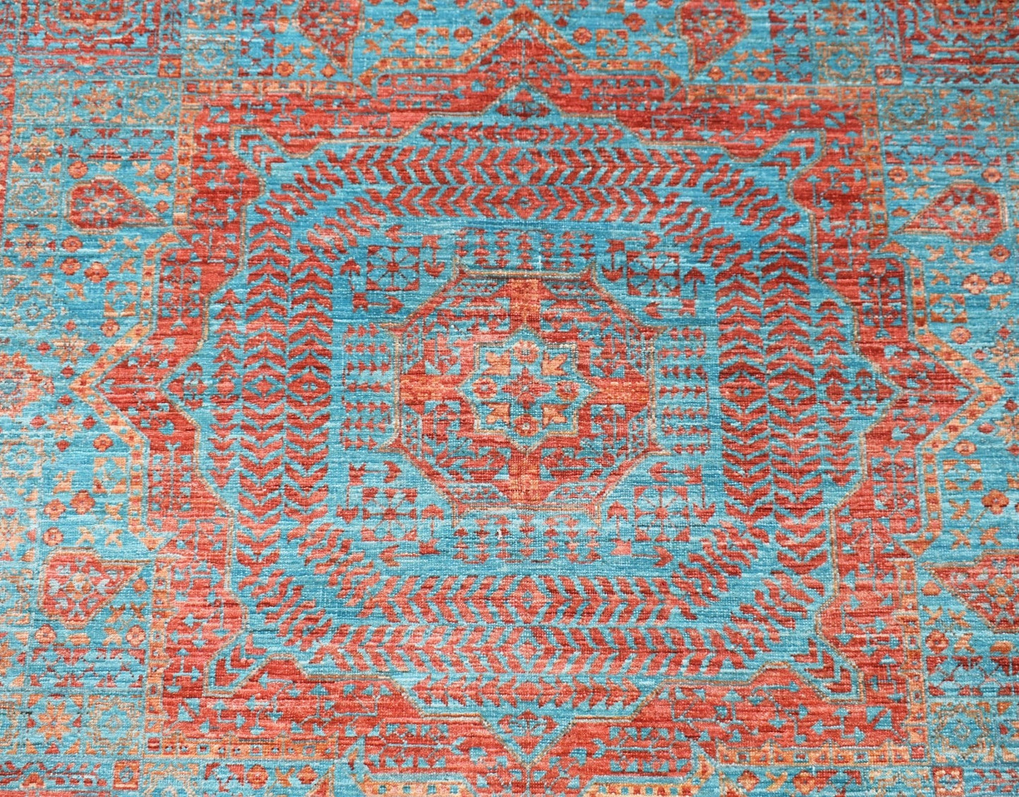 Handwoven Afghan Chobi rug featuring a detailed red Mamluk medallion on a vibrant blue background.