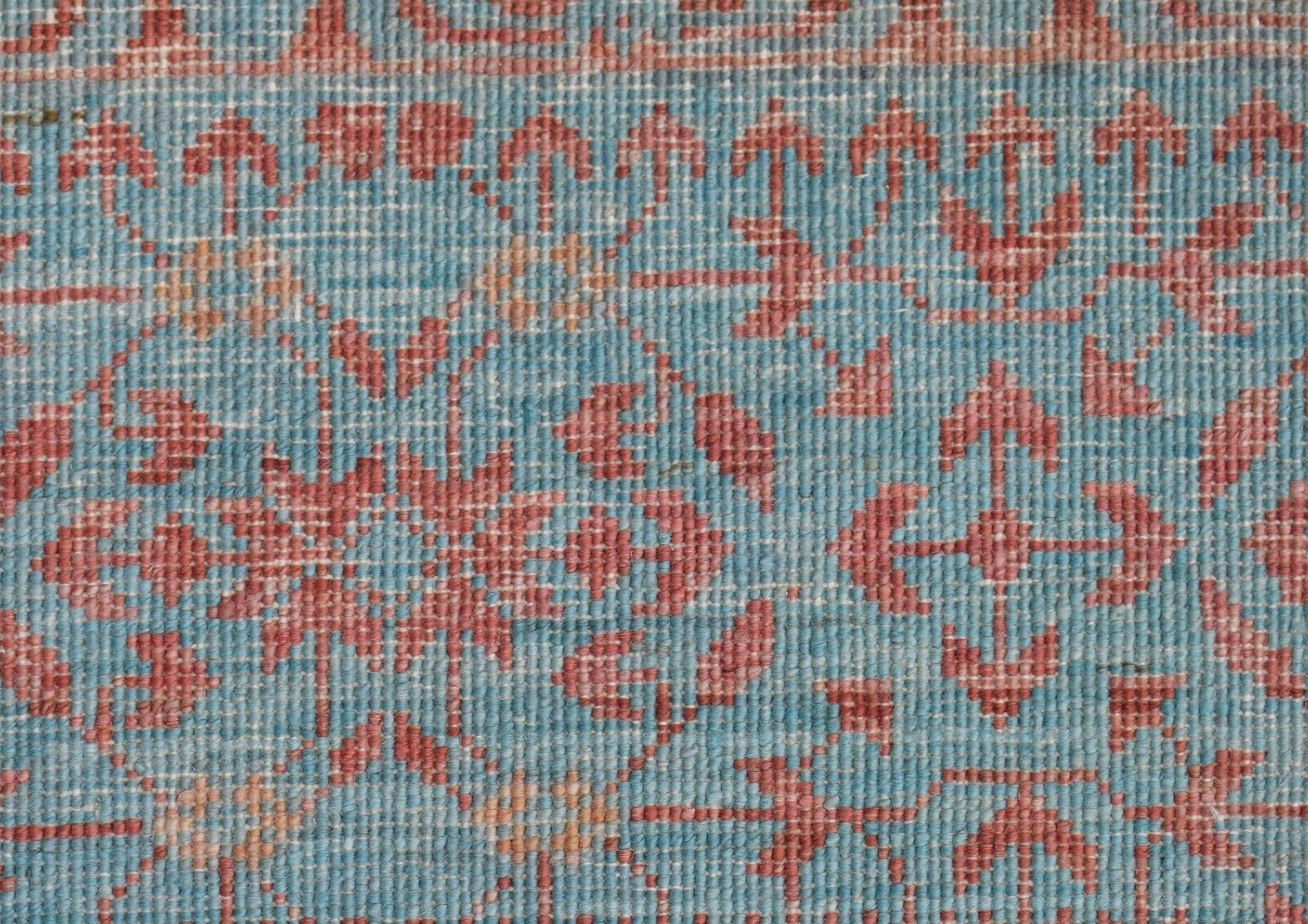A close-up of a handwoven Afghan Chobi rug featuring a detailed Mamluk pattern in blue and red.