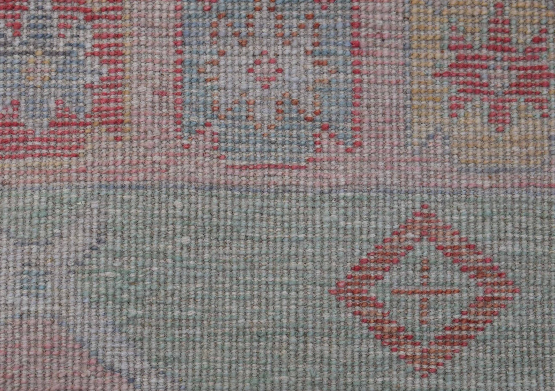 A handwoven wool runner featuring a transitional Oushak pattern in soft, muted tones.