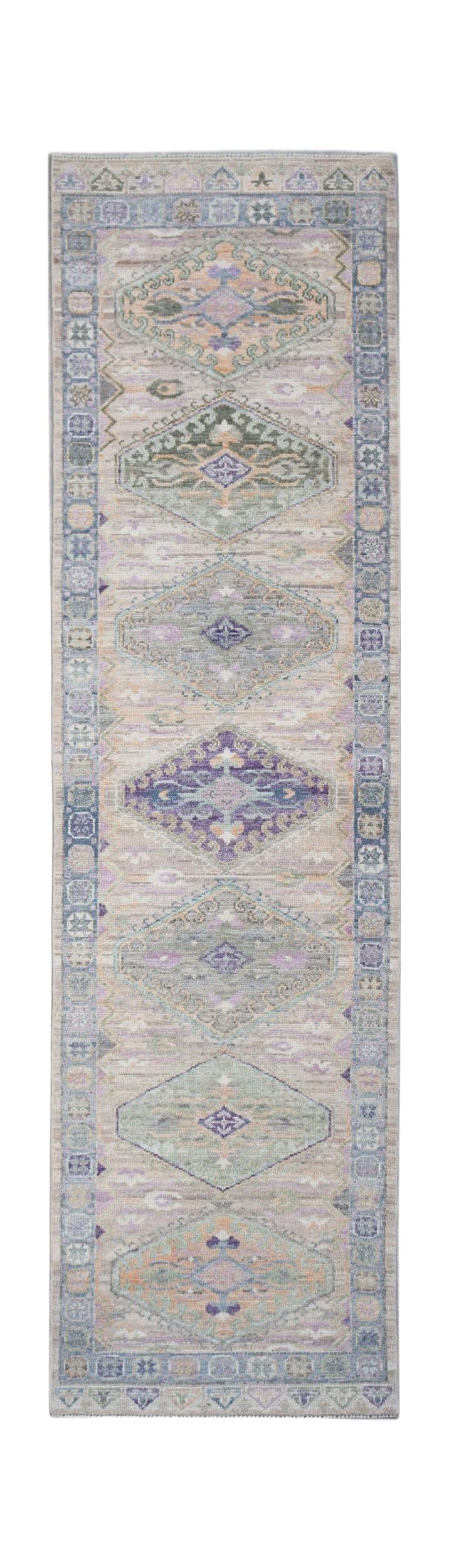 A handwoven transitional Oushak runner rug featuring a repeating diamond pattern in muted tones.
