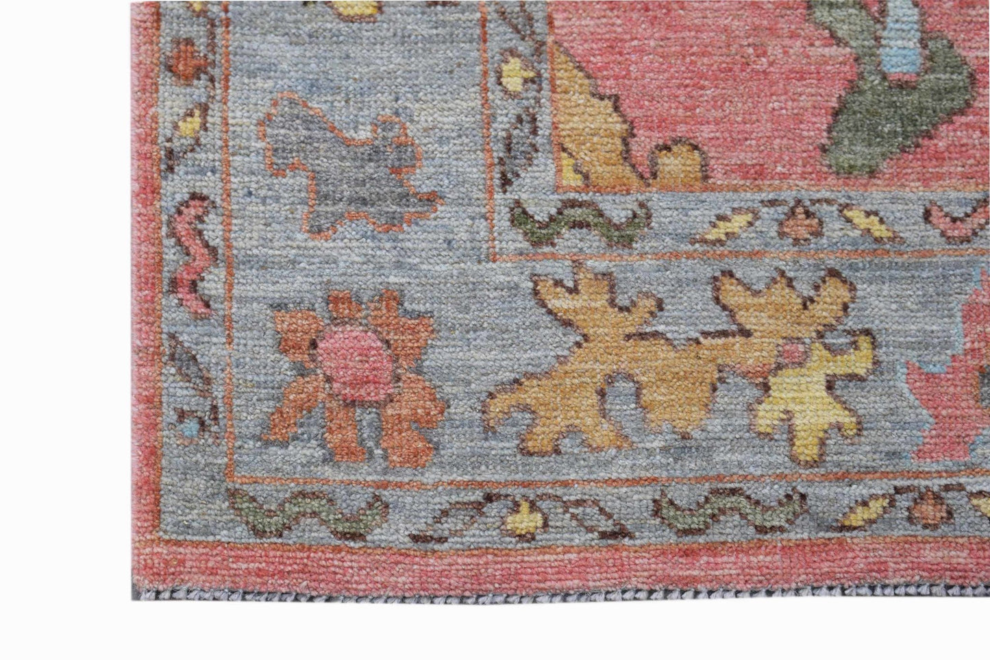 A transitional Oushak runner featuring a floral pattern in muted pink, blue, and yellow tones.