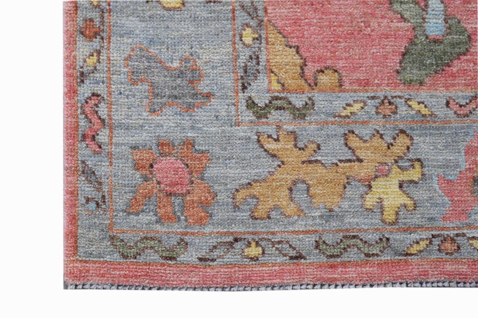 A transitional Oushak runner featuring a floral pattern in muted pink, blue, and yellow tones.