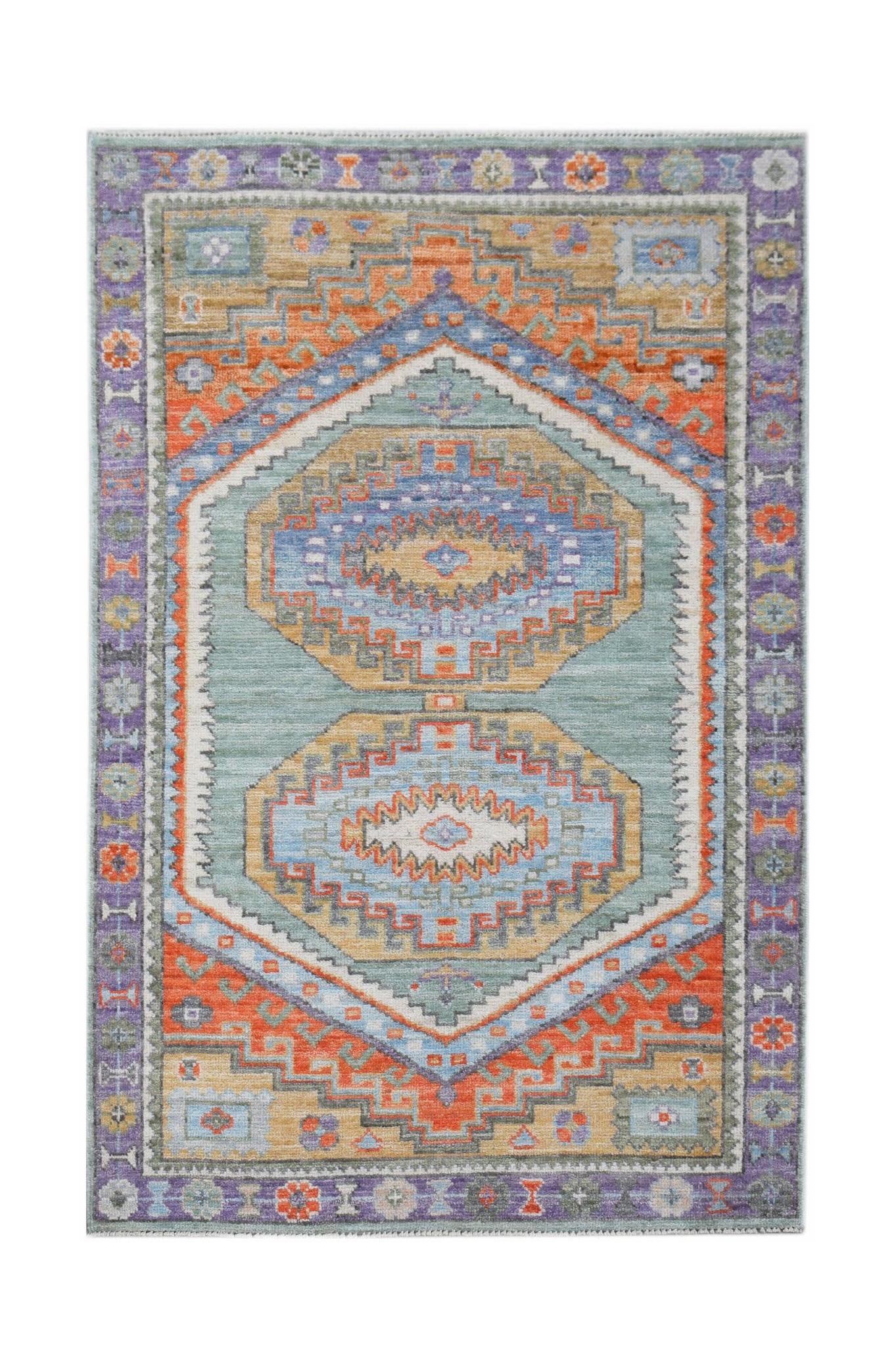 A handwoven transitional Oushak rug featuring geometric patterns in blue, orange, and tan tones.
