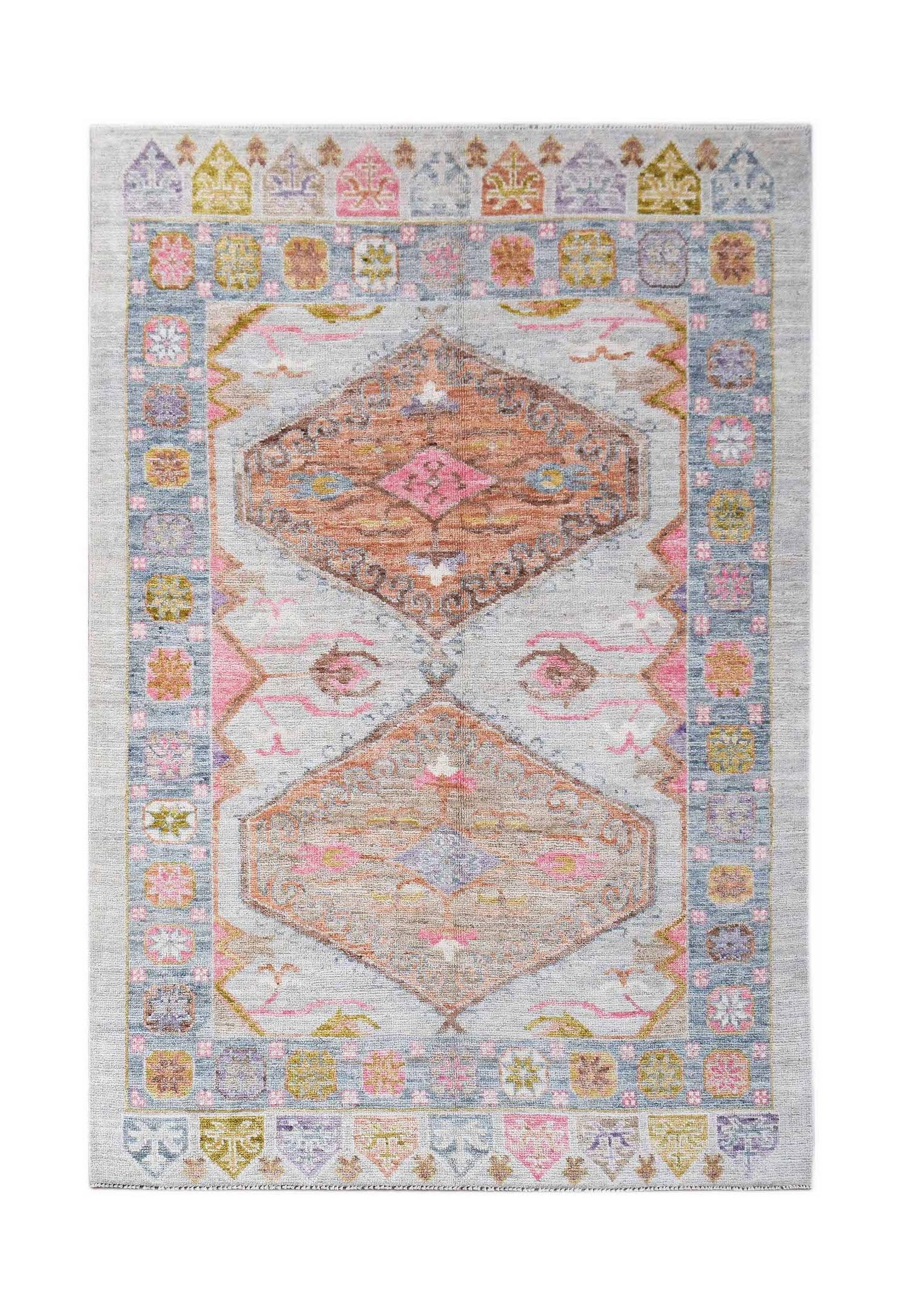 A handwoven transitional Oushak rug featuring two large geometric medallions in soft pastel tones.