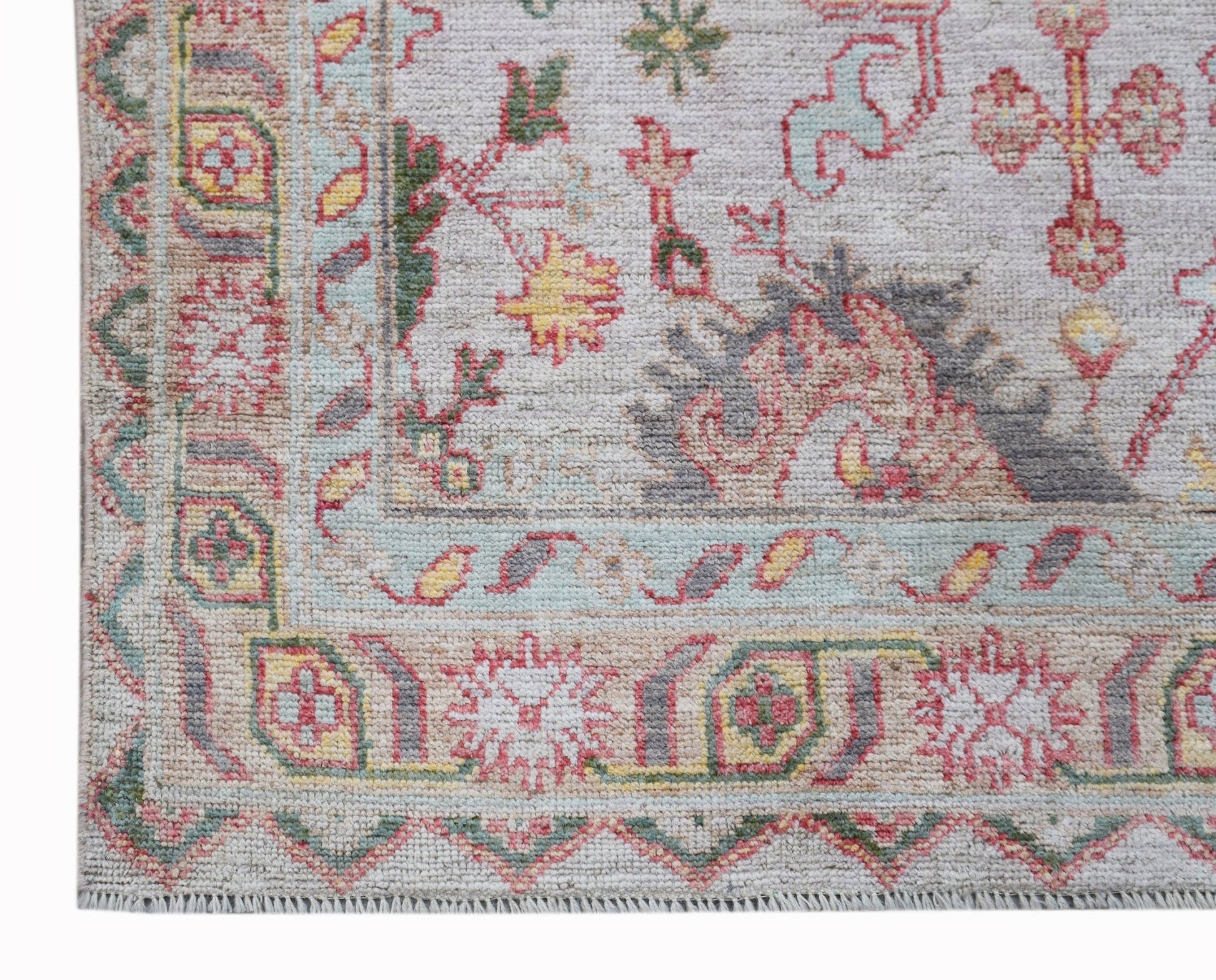 A handwoven transitional Oushak rug featuring a floral pattern in soft, contemporary colors.