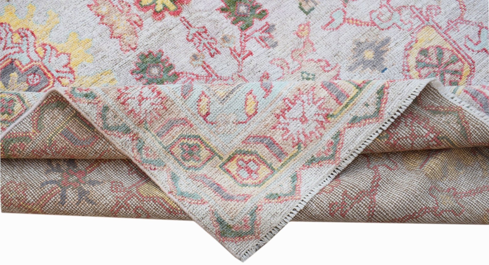 A handwoven transitional Oushak rug featuring a floral pattern in soft pastel tones.