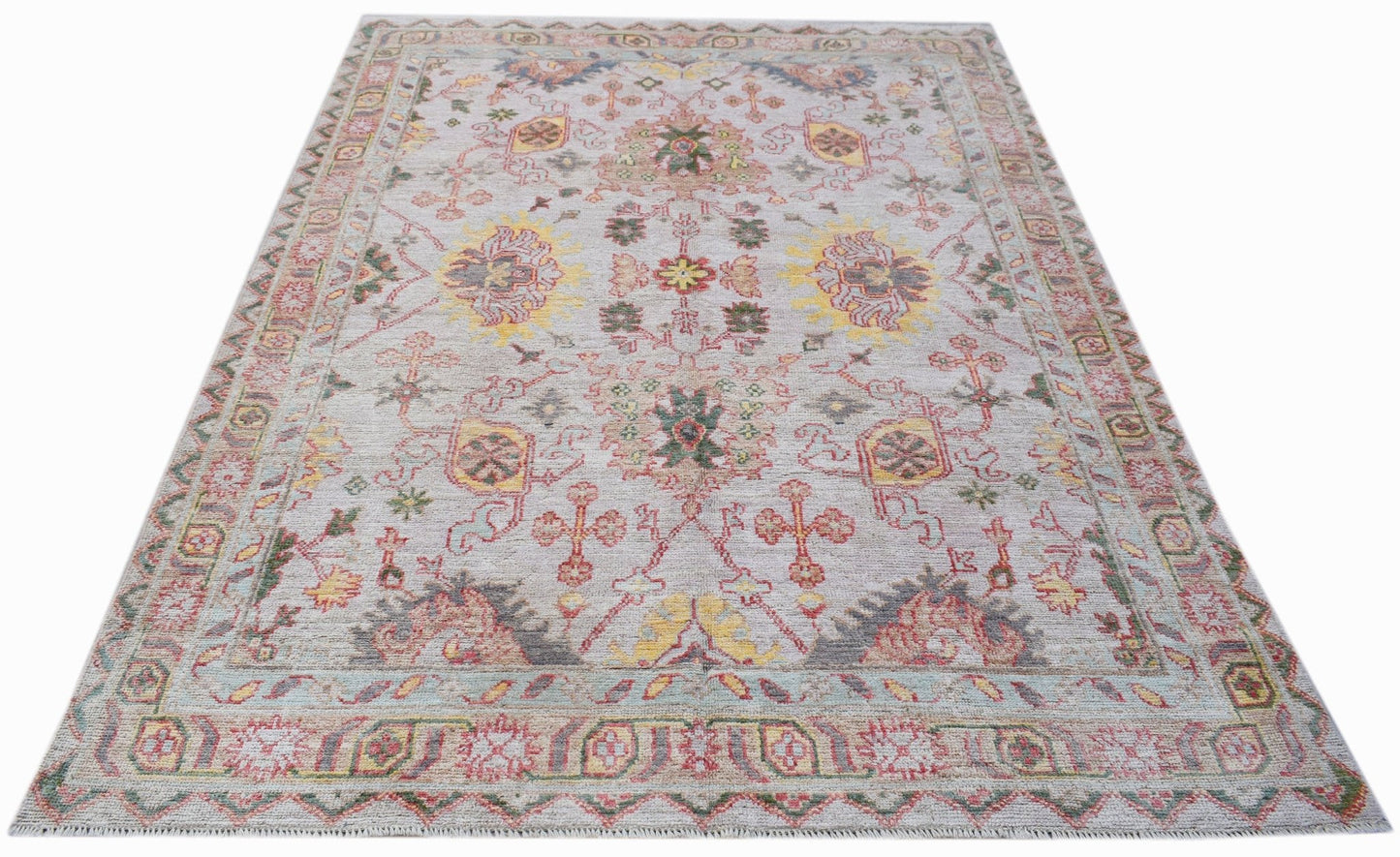 A handwoven transitional Oushak rug featuring a floral pattern in soft, contemporary colors.