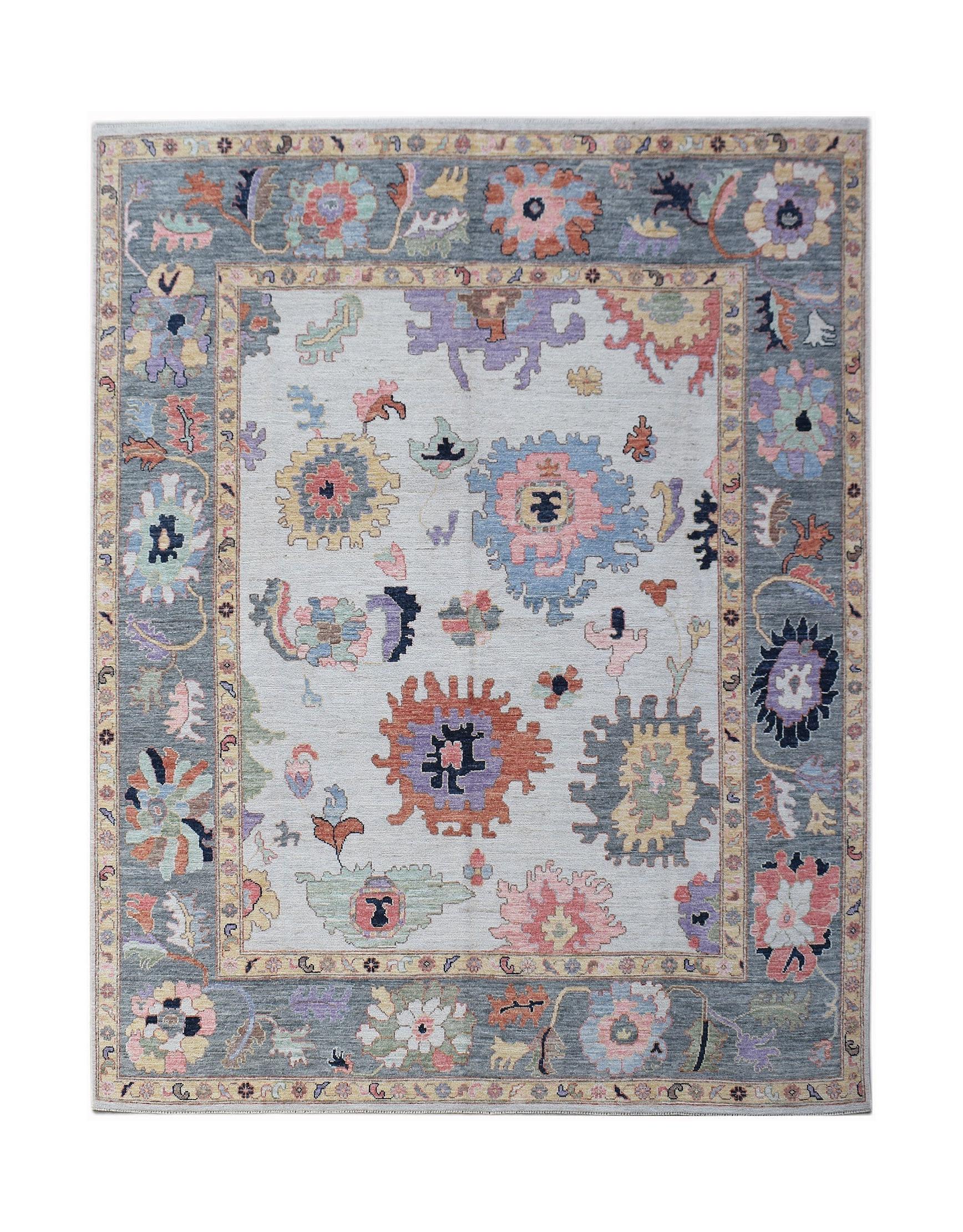 A handwoven transitional Oushak rug featuring a floral pattern in soft pastel tones on a grey base.