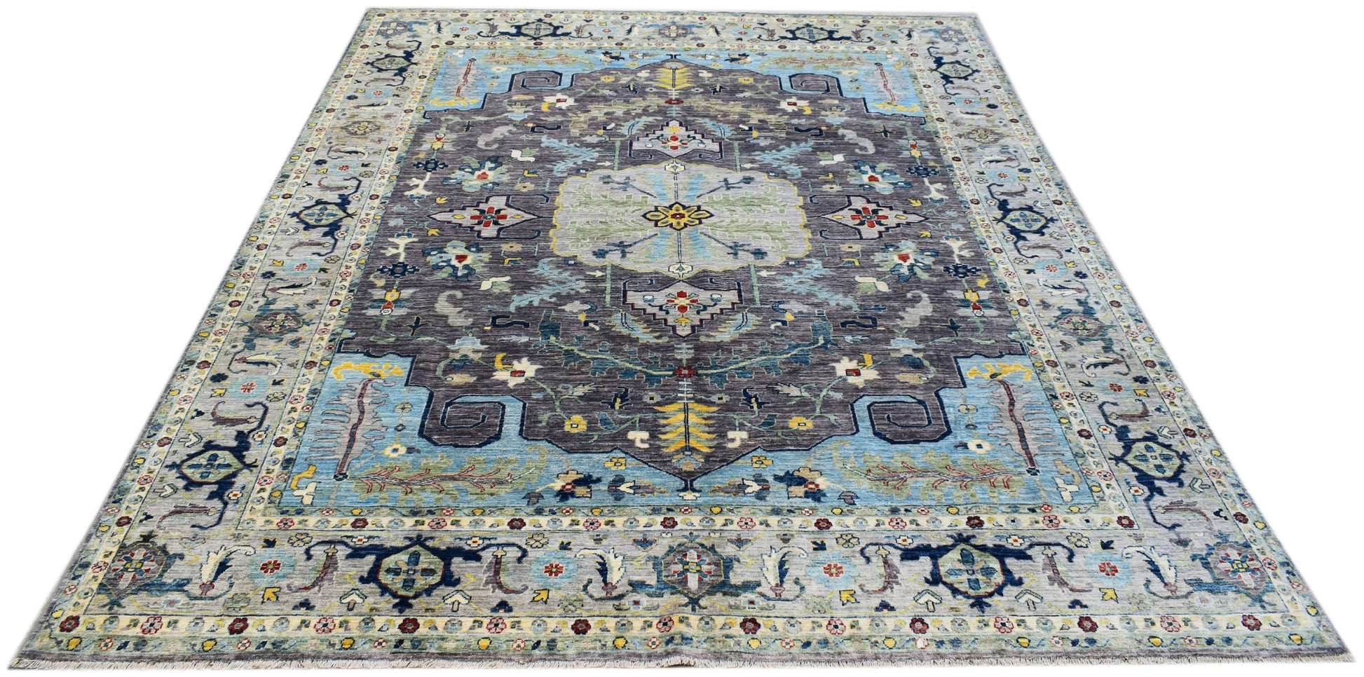 A handwoven transitional Oushak rug featuring a floral pattern in blue, grey, and yellow tones.