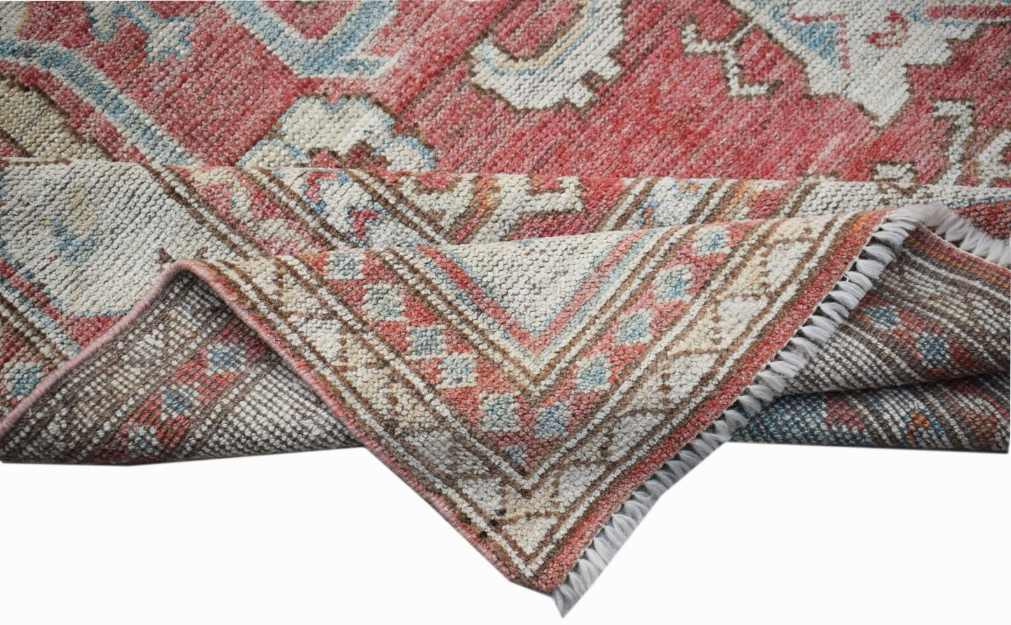 A handwoven transitional Oushak rug featuring a floral pattern in red, blue, and cream tones.