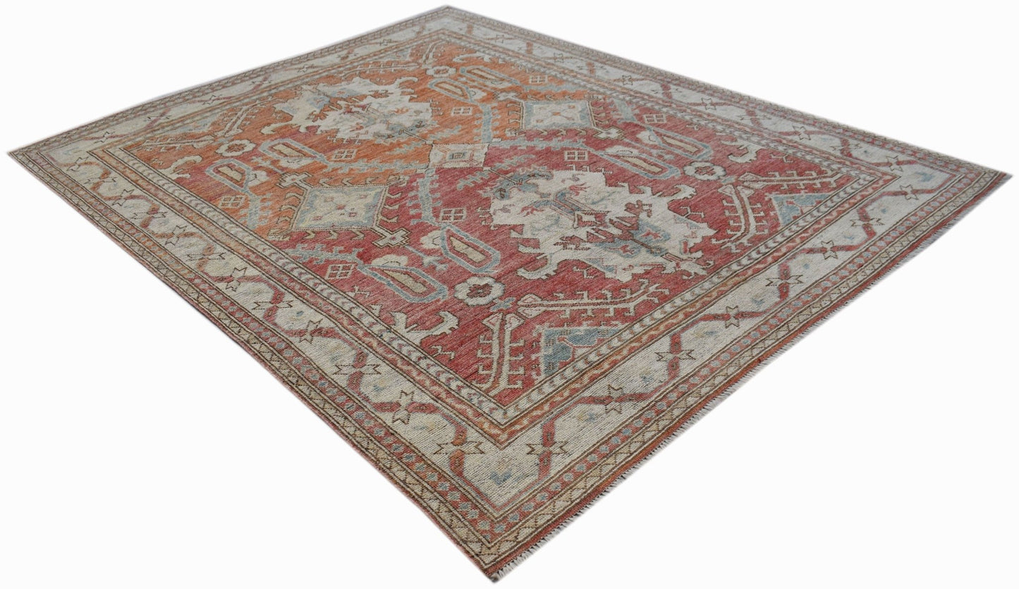 A handwoven transitional Oushak rug featuring a traditional floral pattern in red and cream tones.