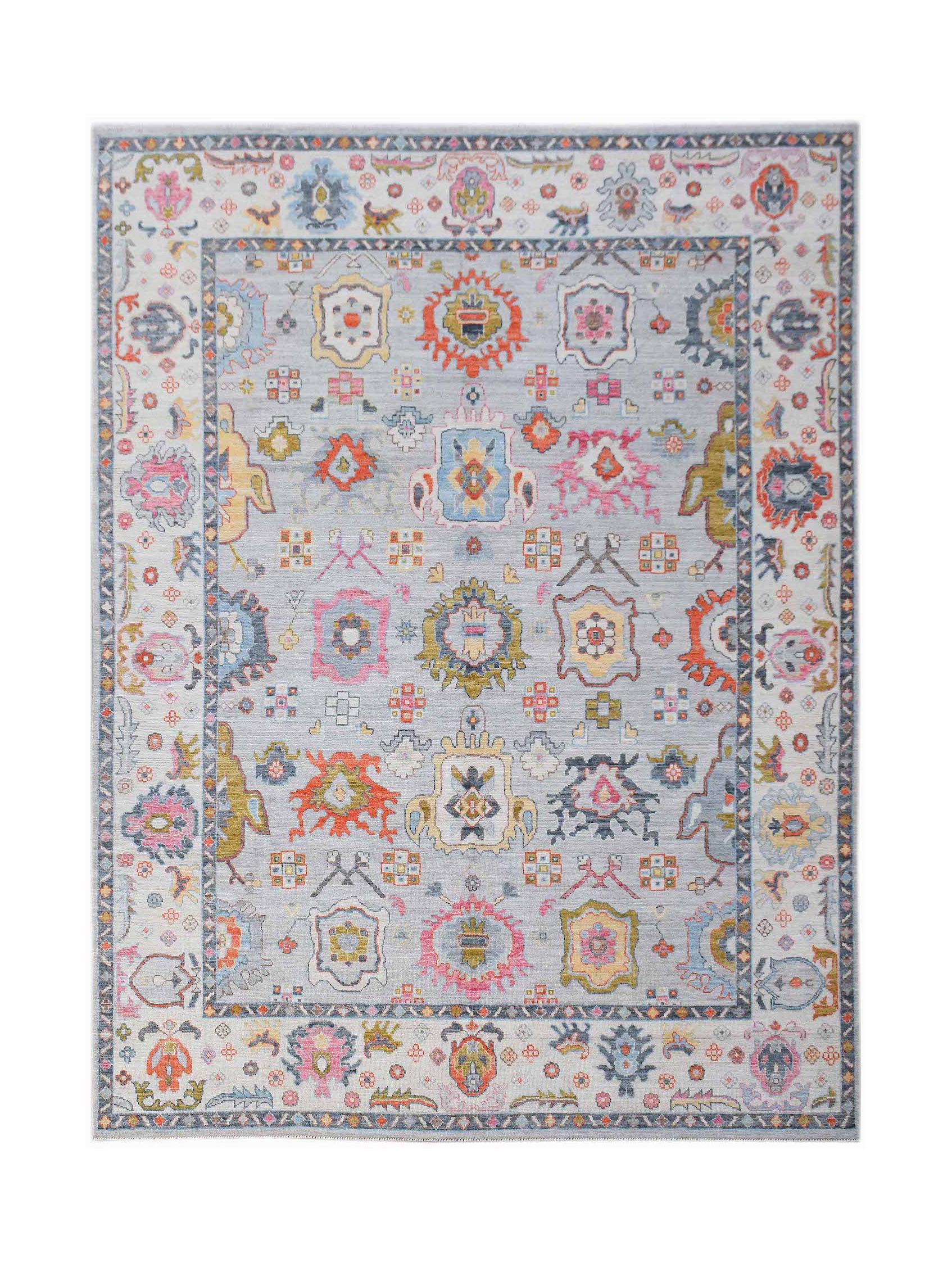 A handwoven transitional Oushak rug featuring a light blue field with colorful floral motifs.