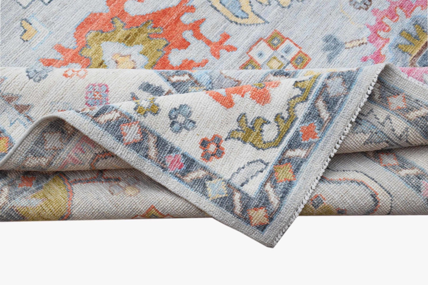 A handwoven transitional Oushak rug featuring a floral pattern in soft, contemporary colors.