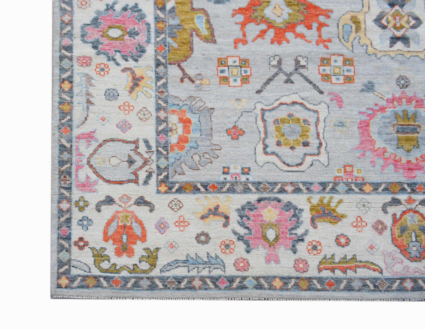 A transitional Oushak rug featuring a light blue field with colorful floral and geometric patterns.
