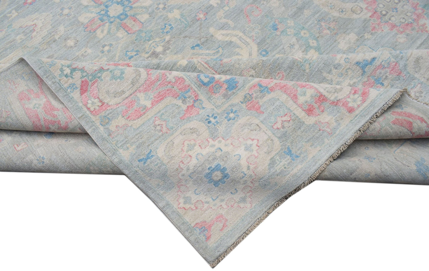 A handwoven transitional Oushak rug featuring a floral pattern in soft blue, pink, and cream tones.