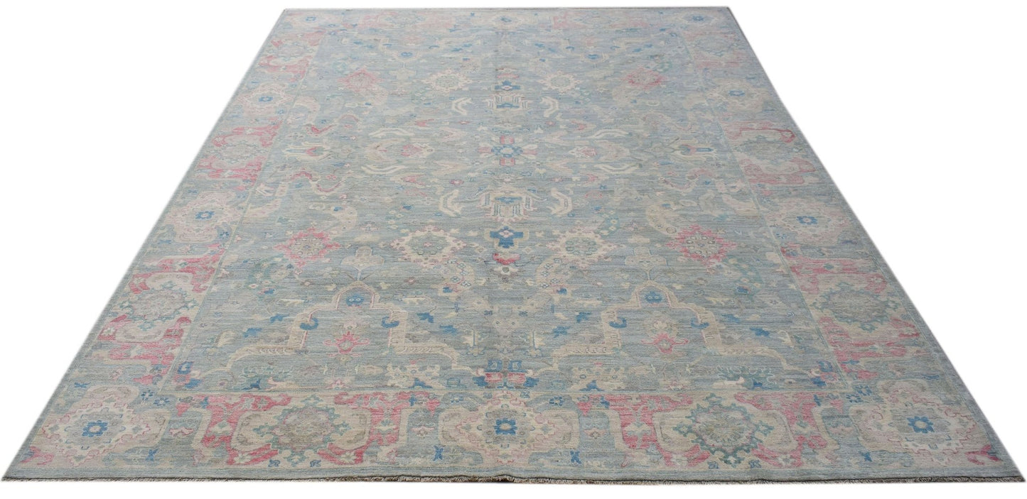 A handwoven transitional Oushak rug featuring a floral pattern in blue, pink, and cream tones.