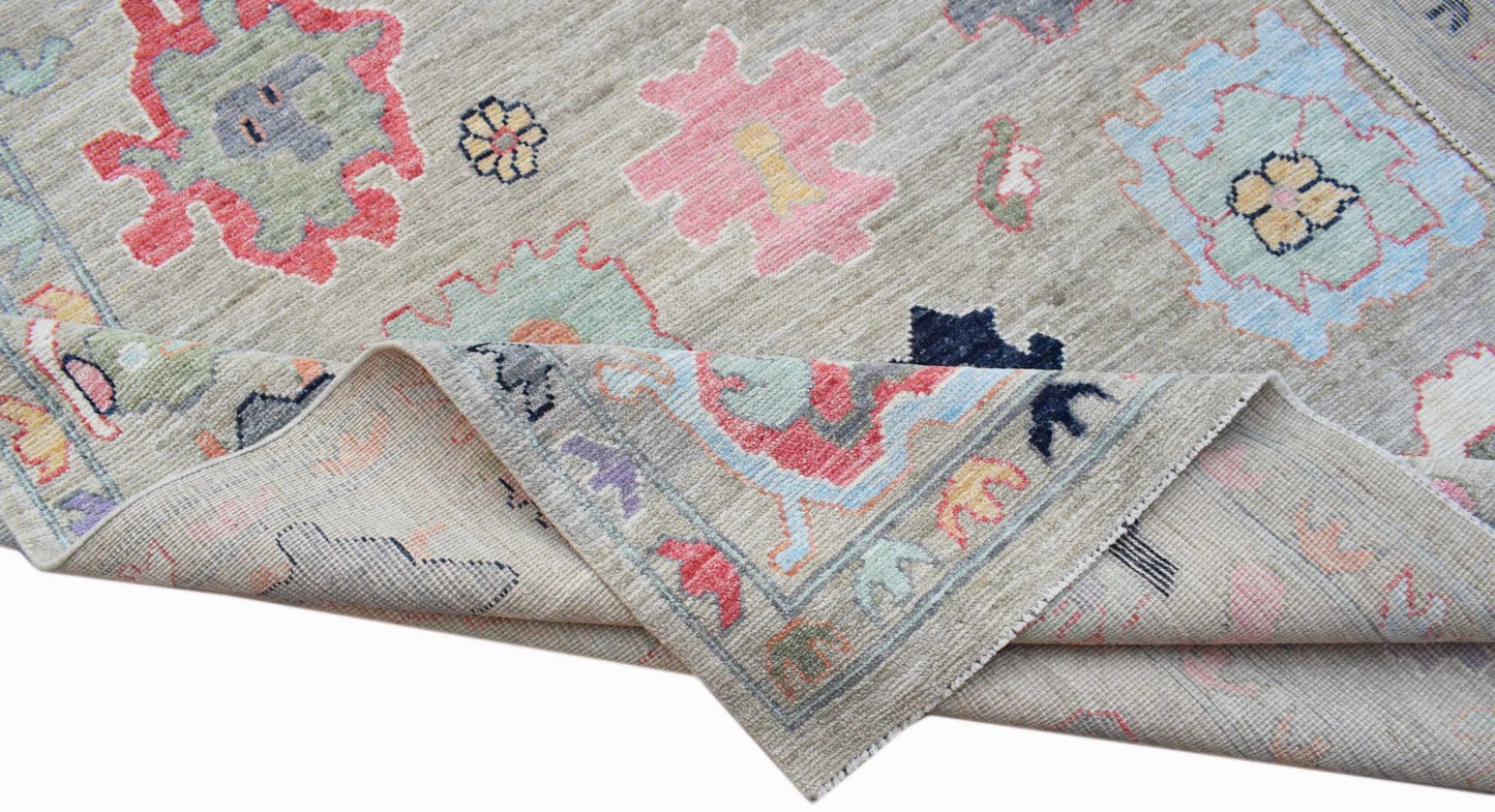 A handwoven transitional Oushak rug featuring a floral pattern in soft pastel colors on wool.