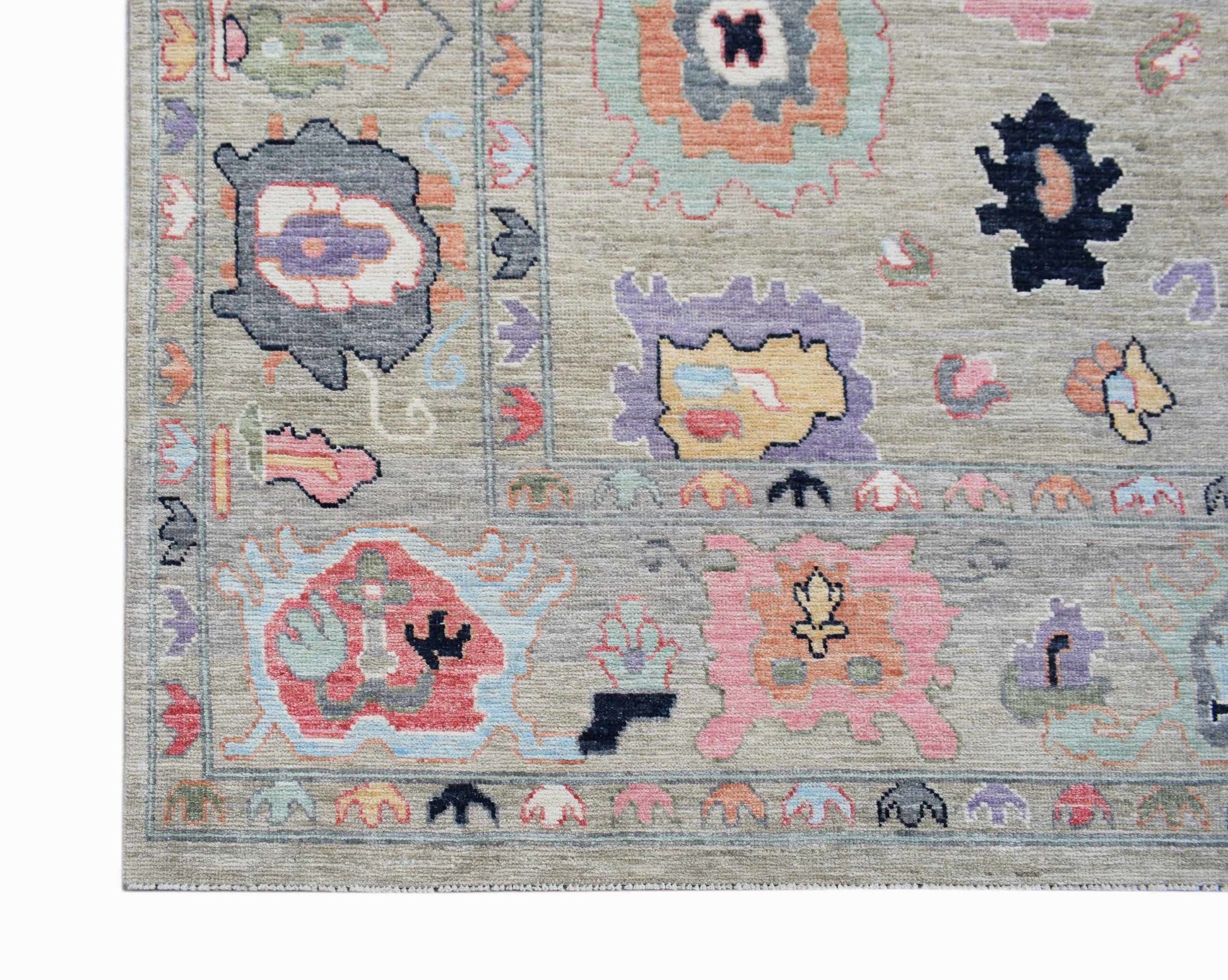 A handwoven transitional Oushak rug featuring a light grey field with colorful floral motifs.