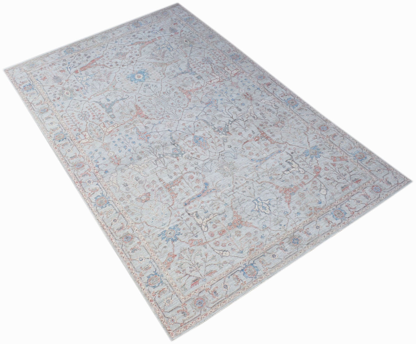 A handwoven transitional Oushak rug featuring a light blue floral pattern on a neutral background.