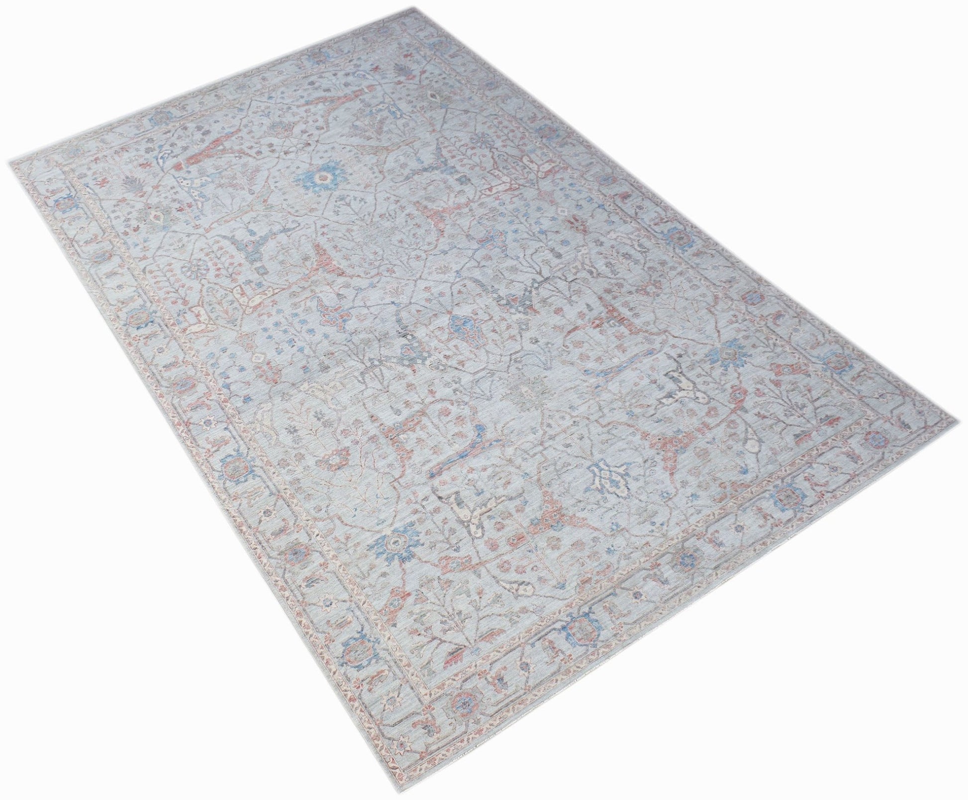 A handwoven transitional Oushak rug featuring a light blue floral pattern on a neutral background.