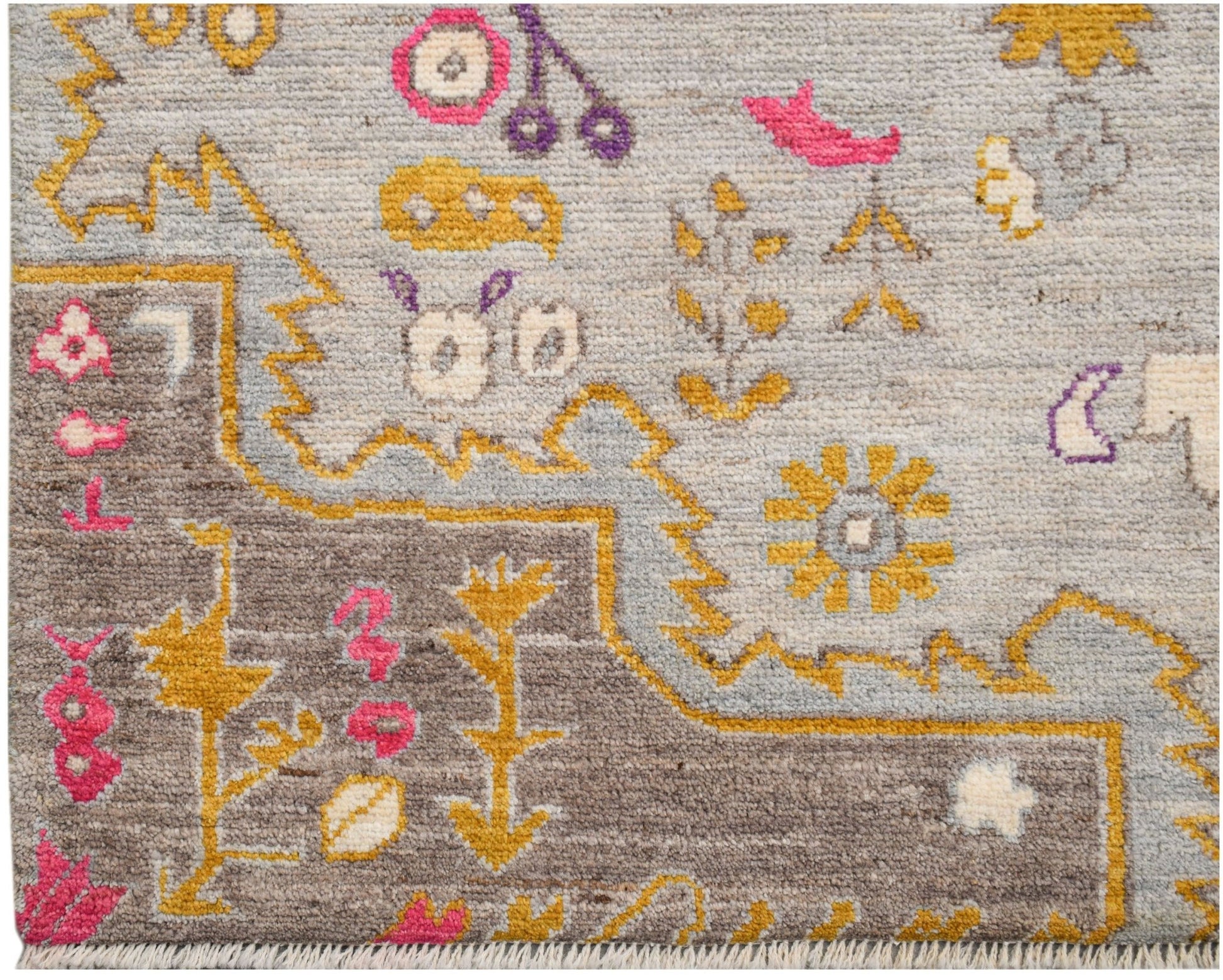 A hand-knotted wool rug featuring a transitional design with geometric motifs in grey and yellow.