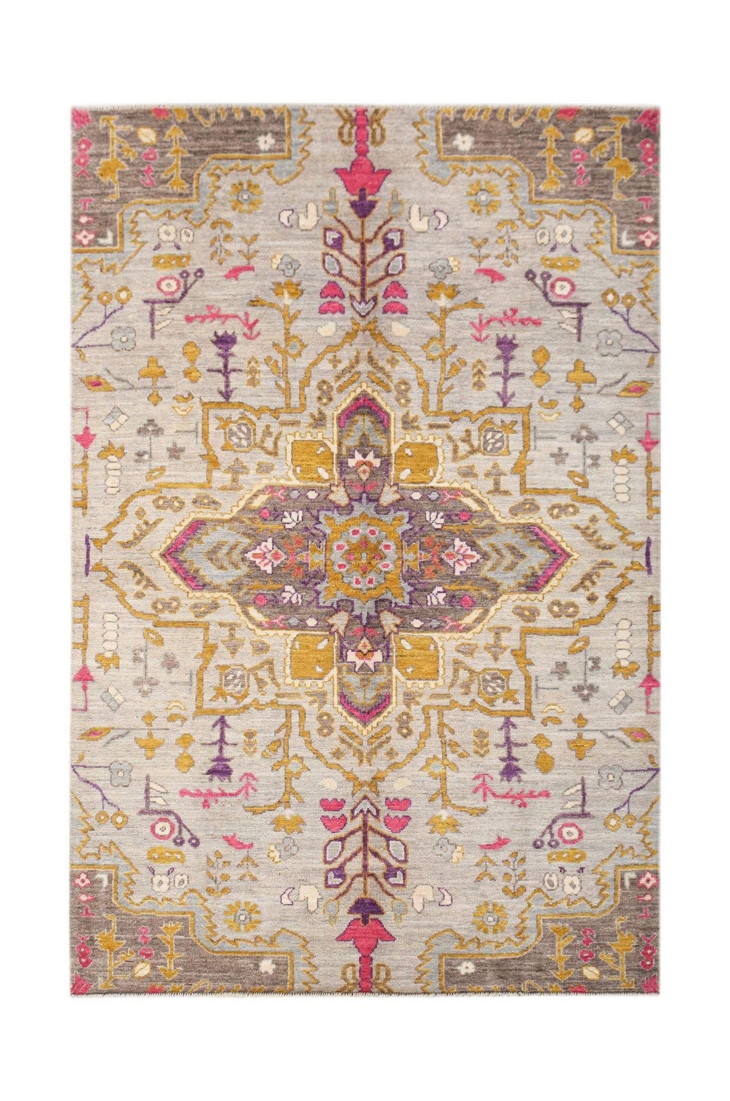A hand-knotted wool rug featuring a transitional geometric medallion in grey, gold, and pink.