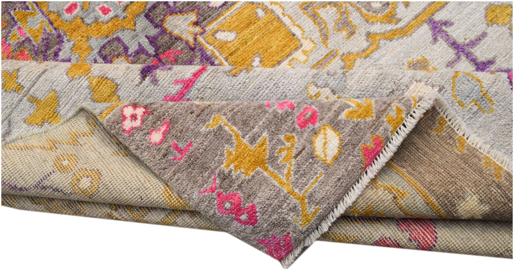 A hand-knotted wool rug featuring a transitional geometric pattern in grey, yellow, and pink.