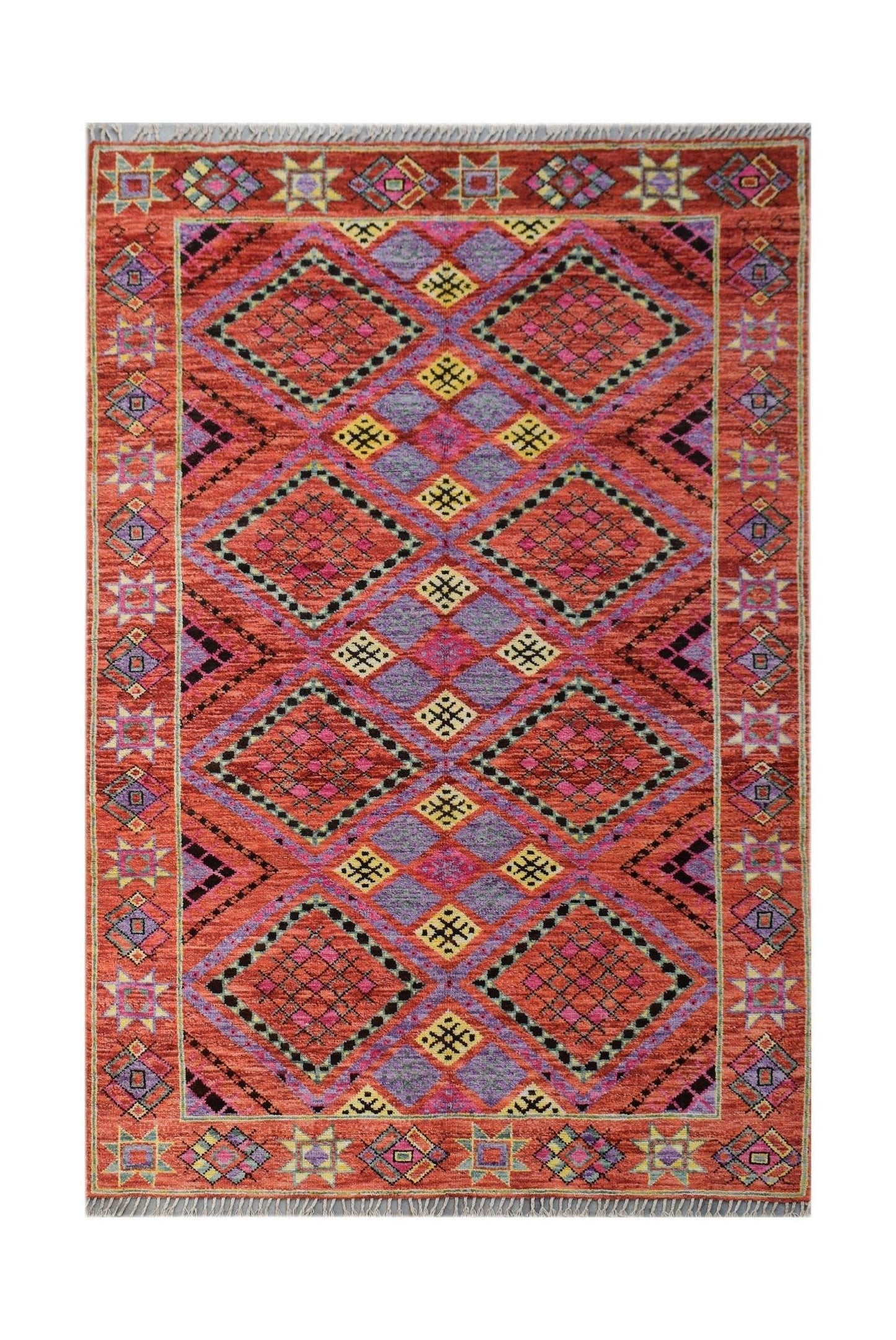 A hand-knotted wool rug featuring a vibrant geometric diamond pattern in red, purple, and yellow.