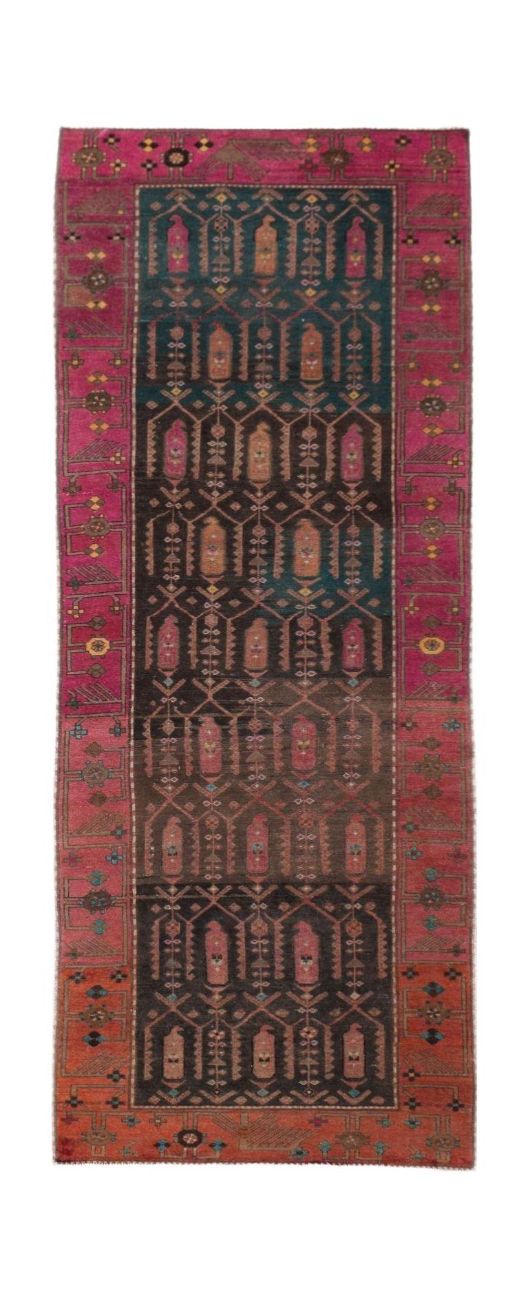 A handmade vintage Persian runner featuring a dark central field with repeating geometric motifs.